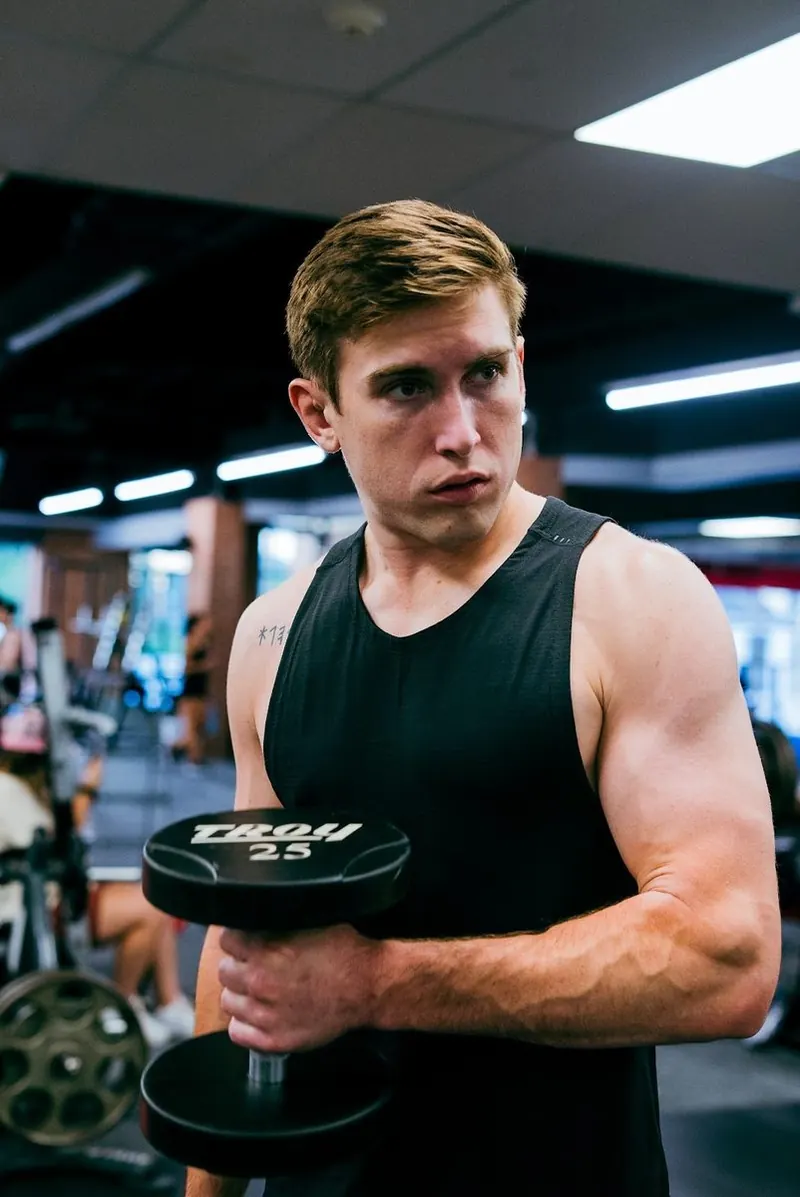 Member curling a dumbbell in the X Shadyside weight room