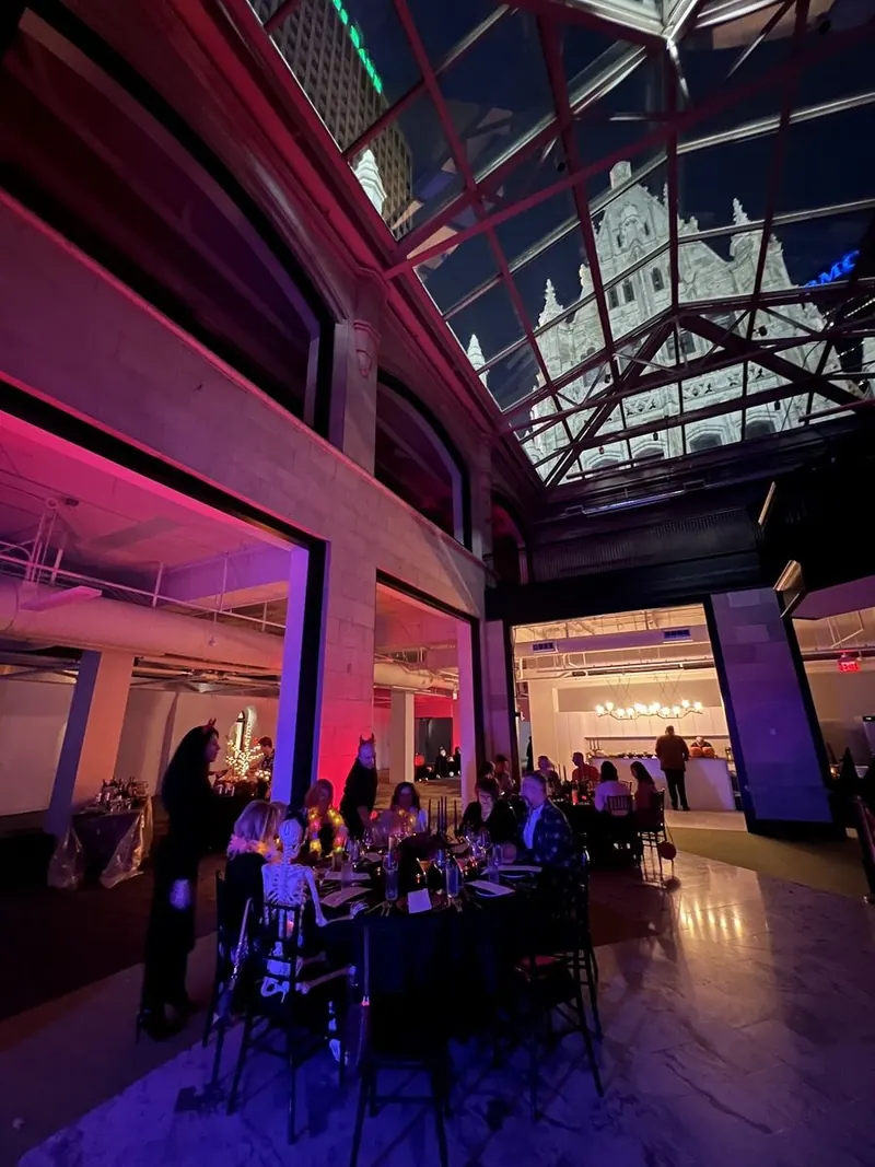 Dinner service under a glass roof lit magenta and blue