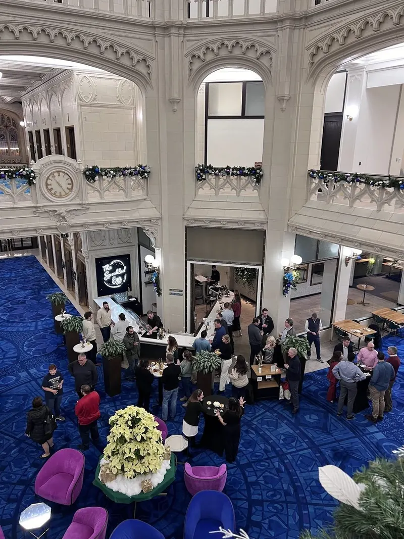 Decorated atrium full of guests at the holiday happy hour