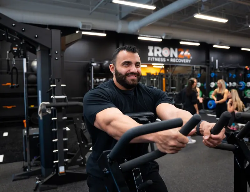 Cardio workout in front of the Iron 24 logo wall
