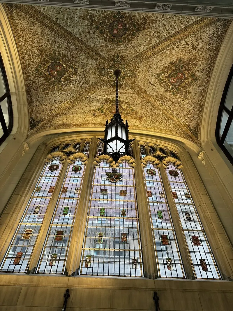 Gilded vaulted ceiling over tall stained-glass windows