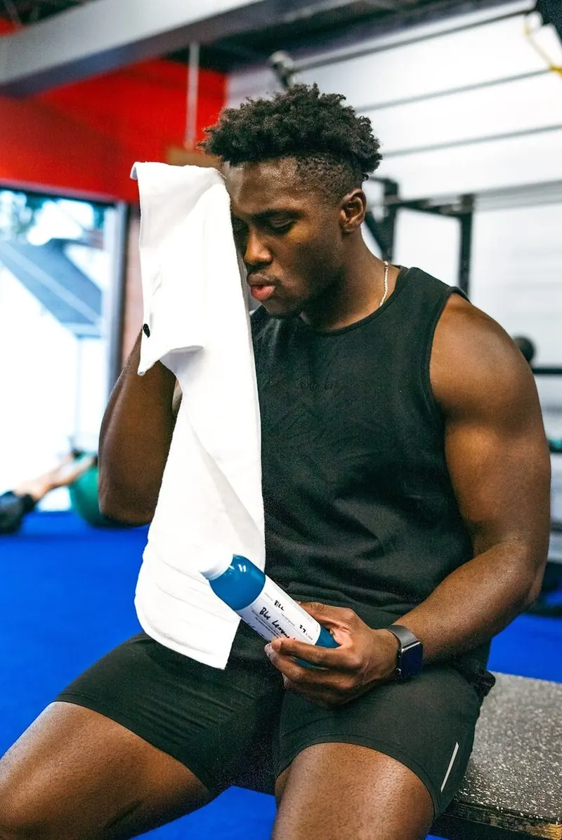 Member resting with a towel and water bottle between sets