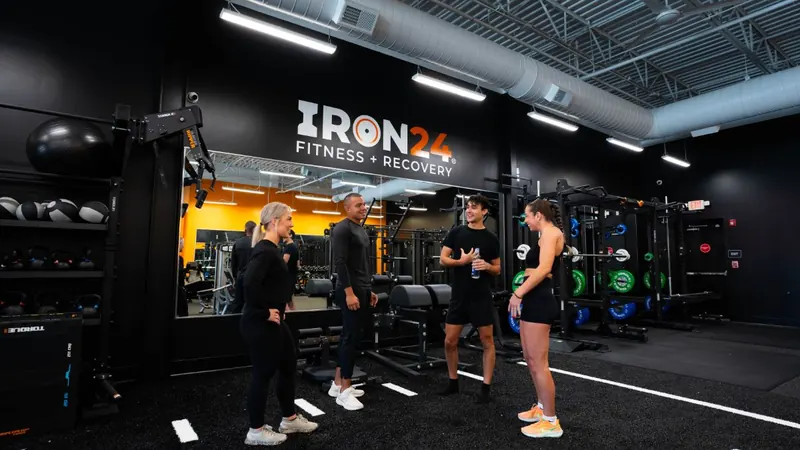 Trainers and members talking on the Iron 24 gym floor