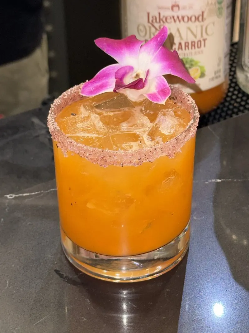 Orange cocktail with an orchid garnish at a lobby restaurant