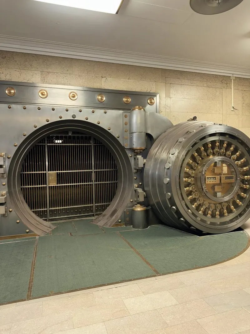 The open and closed safe deposit vault doors side by side